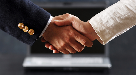 hands shaking together representing a symbol of connection in the business place, custom company rings bind that.